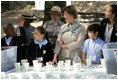 Mrs. Laura Bush and children from the Adam Clayton Powell Jr. Elementary School (P.S. 153) and the Boys and Girls Club of Harlem do 'cup planting' as part of the First Bloom program at the Hamilton Grange National Memorial in New York City, Sept. 24, 2008. The children will take care of the seedlings in the cups throughout the winter and plant them in the park in the spring.