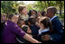 Mrs. Laura Bush receives a big group hug from children visiting from the Adam Clayton Powell Jr. Elementary School (P.S. 153) and the Boys and Girls Club of Harlem at the conclusion of a First Bloom program at the Hamilton Grange National Memorial in New York City, Sept. 24, 2008. The First Bloom program is a national conservation education program for the National Park Foundation that encourages young people to protect the environment in America's National Parks and in their own back yards. 