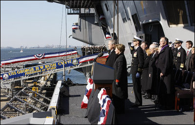 President George W. Bush stands with Mrs. Laura Bush during the playing of the national anthem at the commissioning ceremony of the USS George H. W. Bush (CVN 77) aircraft carrier Saturday, Jan 10, 2009 in Norfolk, Va., in honor of his father, former President George H. W. Bush, seen at right.