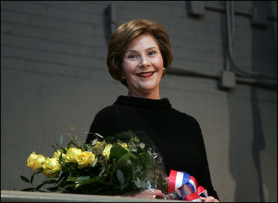 Mrs. Laura Bush stands with a bouquet presented along with the Department of Defense Outstanding Public Service Award by U.S. Secretary of Defense Robert Gates during a military appreciation Tuesday, Jan. 6, 2009, in honor of President George W. Bush's tenure as Commander-in-Chief.