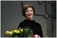 Mrs. Laura Bush stands with a bouquet presented along with the Department of Defense Outstanding Public Service Award by U.S. Secretary of Defense Robert Gates during a military appreciation Tuesday, Jan. 6, 2009, in honor of President George W. Bush's tenure as Commander-in-Chief.