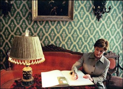 Laura Bush signs the guest registry after touring the home of Russian author Feodor Dostoevsky June 2, 2003, in Saint Petersburg, Russia.