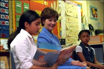 Laura Bush listens as a student at Caesar Chavez Elementary School reads during a "Ready to Read Ready to Learn" visit to the school in Hyattsville, Maryland, Feb., 26, 2001.