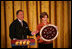 Mrs. Laura Bush and U.S. Mint Director Ed Moy hold up the Dolley Madison Gold Coin Monday, Nov. 19, 2007, in the East Room. 
