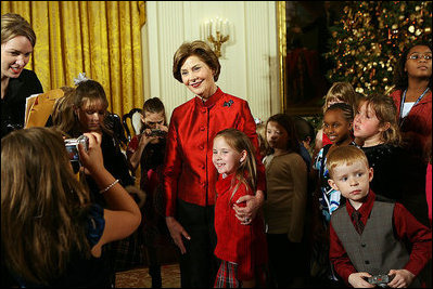 Mrs. Laura Bush poses for a photo with a young guest following the performance of the Ford's Theatre cast members presentation of “A Christmas Carol,” Monday, Dec. 3, 2007, at the White House Children’s Holiday Reception.