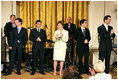 Mrs. Laura Bush stands with members of the cast from the Tony award-winning musical "Jersey Boys" as they perform during a luncheon for Senate Spouses in the East Room, Monday, June 12, 2006. White House photo by Shealah Craighead 