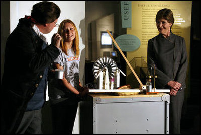Mrs. Laura Bush watches as David Temple, actor portraying Benjamin Franklin, performs a demonstration related to static electricity at the Houston Museum of Natural Science, Wednesday, October 18, 2006, with the help of a 6th grade student from the Baines Middle School in Houston, TX.