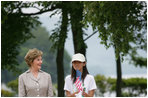 Mrs. Laura Bush stands with Natsumi Kagawa, age 11, after planting a tree at the Toyako New Mount Showa Memorial Park Wednesday, July 8, 2008, during the ceremony in Hokkaido, Japan. The wives of each of the G8 Summit leaders planted a small evergreen tree along a park walkway.