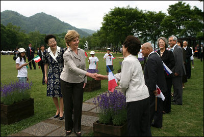 Mrs. Laura Bush, accompanied by Mrs. Kiyoko Fukuda, spouse of the Prime Minister of Japan, left, is greeted at Toyako's New Mount Showa Memorial Park where she participated in a tree planting ceremony with other G8 spouses on Wednesday, July 9, 2008, in Hokkaido, Japan.