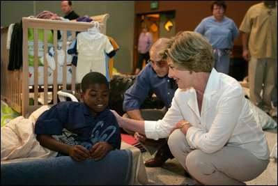 Laura Bush visits with a young boy displaced by Hurricane Katrina in the Cajundome at the University of Louisiana in Lafayette, La., Friday, Sept. 2, 2005.