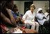 Laura Bush visits with people affected by Hurricane Katrina in the Cajundome at the University of Louisiana in Lafayette, La., Friday, Sept. 2, 2005.