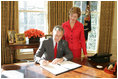 With Laura Bush looking on, President George W. Bush signs a proclamation designating February as American Heart Month in the Oval Office, Feb. 1, 2005. The proclamation encourages awareness of factors leading to heart disease such as smoking, high cholesterol, lack of exercise, obesity and diabetes.