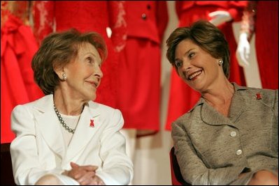 Laura Bush and former First Lady Nancy Reagan share a moment Thursday, May 12, 2005, at the John F. Kennedy Center for the Performing Arts during the unveiling of The Heart Truth’s First Ladies Red Dress Collection.