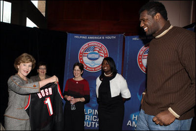 Mrs. Laura Bush holds an National Basketball Association basketball jersey presented to her by NBA player Mr. Greg Oden of the Portland Trail Blazers, during the regional conference on Helping America's Youth at the Portland Center for the Performing Arts in Portland, Ore. Also attending the presentation are, from left, Ms. Robyn Williams, executive director, Portland Center for the Performing Arts; Mrs. Mary Oberst, first lady of Oregon; and student, Ms. Shantel Monk.