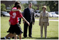 Mrs. Laura Bush and Mike Gottfried, CEO of Team Focus, watch Team Focus participants run a relay race Thursday, June 21, 2007, in Mobile, Ala., during a visit to Team Focus's National Leadership Camp, as part of Helping America’s Youth initiative. Team Focus is a faith-based, nonprofit organization devoted to improving the lives of young men, ages 10-18, without fathers in their lives.