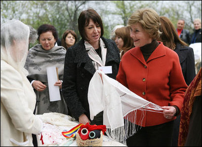 Mrs. Laura Bush spends a moment with a traditional handicraft artisan at Dimitrie Gusti Village during an outing Thursday, April 3, 2008, with NATO spouses to the Bucharest open-air museum.