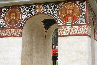 Mrs. Laura Bush peers through an archway at the Dimitrie Gusti Village in Bucharest Thursday, April 3, 2008, as she joined fellow spouses of NATO leaders for a tour of the open-air museum.