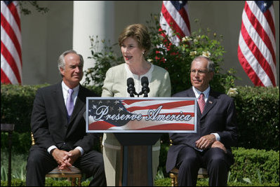 Mrs. Laura Bush is joined by U.S. Secretary of the Interior Dirk Kempthrone, left, and Jon Nau III, chairman of the Advisory Council on Historic Preservation, as she addreses guests in the White House Rose Garden, Wednesday, May 9, 2007, during the Preserve America President Awards ceremony. 