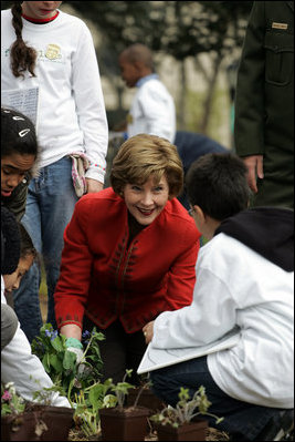 Mrs. Laura Bush helps children plant flowers at the First Bloom Event, Monday, April 21, 2008, during her visit to celebrate National Park week at the Castle Clinton National Monument in New York City.