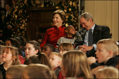 President George W. Bush and Mrs. Laura Bush share a moment with Malik Lawson during the Children's Holiday Performance Monday, Dec. 3, 2007, at the White House. The 7-year-old is the son of TSgt. Sherry Martin, currently serving in Iraq.