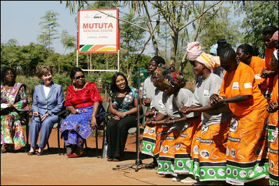 Mrs. Laura Bush is greeted by a chorus of singers as she joins her fellow participants at the Mututa Memorial Center Thursday, June 28, 2007, in Lusaka, Zambia. Pictured, from left are: Mrs. Martha Chilufya, Director of the Mututa Memorial Center; Maureen Mwanawasa, First Lady of Zambia, and Melinda Doolittle, American Idol finalist.