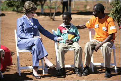 Mrs. Laura Bush talks with Raphael Lungo, 10, during a discussion with caregivers and beneficiaries of the Mututa Memorial Center Thursday, June 28, 2007, in Lusaka, Zambia. The center provides many humanitarian services including home-based care for people living with HIV/AIDS, care for orphans and promotes abstinence and faith for youth.