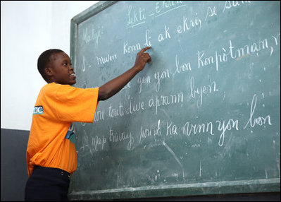 A student at the IDEJEN educational program reads from a chalkboard Thursday March, 13, 2008, during Mrs. Laura Bush's visit to the program at the College de St. Martin Tours in Port-au-Prince, Haiti.