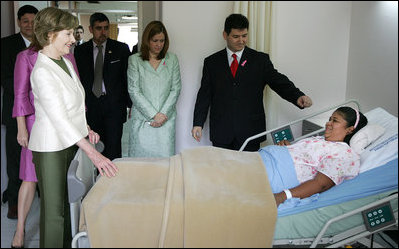 Mrs. Laura Bush spends a moment with Ms. Robalba Robinson, a breast cancer patient recovering from recent reconstructive surgery, during a visit Friday, Nov. 21, 2008, to the National Oncology Institute in Panama City. Joining her is Mrs. Vivian Fernandez de Torrijos, First Lady of Panama, in pink, and Dr. Rosario Turner, Panama's Minister of Health. The man at right is unidentified.