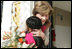 Mrs. Laura Bush hugs a young girl after she was presented with a bouquet of flowers upon her arrival welcome to the San Clemente Health Center Friday, Nov. 21, 2008, in San Clemente, Peru. Mrs. Bush visited the center and participated in interactive demonstrations depicting community-based health training.