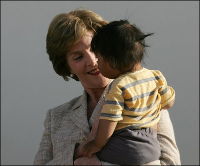 Mrs. Laura Bush smiles as she holds a child during a visit Friday, Nov. 21, 2008, to the San Clemente Health Center in San Clemente, Peru. The center serves an average of 80 patients a day in the town of 25,000 located six miles north of Pisco, the site of the August 2007, 8.0-magnitude earthquake.