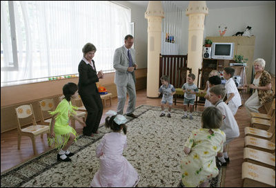Mrs. Laura Bush does the chicken dance with youngsters Friday, July 14, 2006, during a tour and roundtable at the Pediatric HIV/AIDS Clinical Center of Russia in St. Petersburg, Russia.