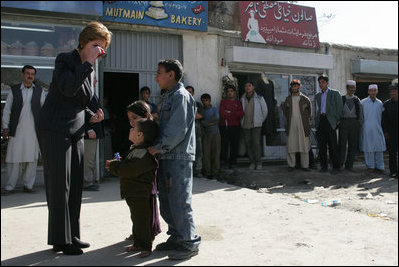 Laura Bush shows a few young boys how to use a kaleidoscope Wednesday, March 30, 2005, during her visit to Afghanistan.  