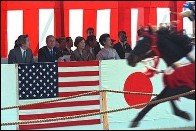 Prime Minister Junichiro Koizumi, far left, President George W. Bush, left, Laura Bush, second right, and Kiyoko Fukuda, far right, wife of the Japanese chief cabinet secretary, watch a demonstration of horseback archery during a visit to the Meiji Shrine in Tokyo, Monday, Feb. 18, 2002.