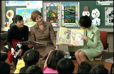 Mrs. Bush and an interpreter listen as Princess Hisako Takamado reads a book she has written, 
