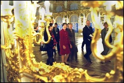 Laura Bush and Ludmila Putin, wife of Russian President Valdimir Putin, are reflected in a gilded mirror as they walk through one of the great halls of Catherine's Palace outside St. Petersburg, Russia.