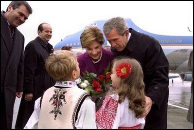 President George W. Bush and Laura Bush are greeted by children at the airport in Bucharest, Romania Saturday, Nov. 23, 2002.