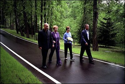 President George W. Bush and Laura Bush walk with Russian President Vladimir Putin and his wife Lyudmila on the grounds of their dacha , May 24, 2002.