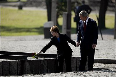 President George W. Bush and Laura Bush place a rose at the end of the railroad tracks at the Memorial Wall at the former Birkenau concentration camp in Oswiecim, Poland, May 31, 2003.