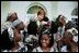 Laura Bush embraces children in the Uganda Children's Choir on the steps of the Oval Office prior to their performance in the Rose Garden June 10, 2003.