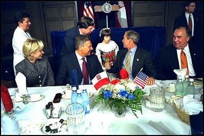 Attending a luncheon at the American-Polish Cultural Center in Troy, Mich., President Bush and President Kwasniewski are visited by one of the center's smaller members. Upon their arrival to the center, the two presidents were greeted by about two dozen children wearing traditional clothing.