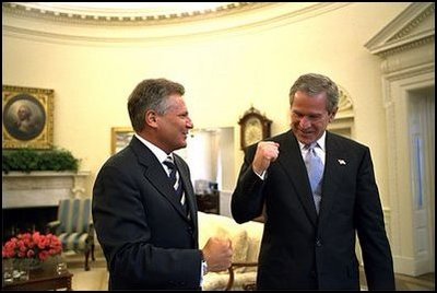 Before starting the first meeting of the day, Presidents Bush and Kwasniewski talk privately in the Oval Office July 17.