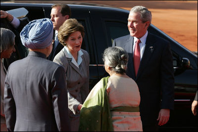 President George W. Bush and Laura Bush are greeted upon their arrival at Rashtrapati Bhavan, New Delhi, India, by India Prime Minister Manmohan Singh and wife, Gursharan Kaur.