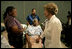 Laura Bush reaches out to a victim of Hurricane Katrina during a visit Friday, Sept. 2, 2005, to the Cajundome at the University of Louisiana in Lafayette.  "The people of this part of the United States, the Lafayette area of Louisiana, are very, very warm people," said Mrs. Bush.  "They've opened their hearts, and many of them have opened their homes, as well, to people from New Orleans -- family members and strangers."