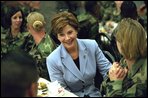 Laura Bush talks with members of the 101st Airborne at Fort Campbell, Kentucky. Known as "The Screaming Eagles," this airborne division took part in the largest airborne assault of World War II and also served in Vietnam. Surrounded by the soldiers, Mrs. Bush shares a turkey dinner with them Wednesday, Nov. 21, 2001. White House photo by Tina Hager.