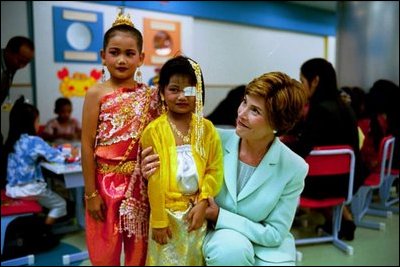 Laura Bush embraces a little girl at the National Institute of Child Health in Bangkok, Thailand, Oct. 21, 2003.