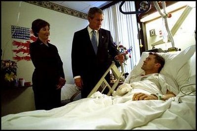 President George W. Bush and First Lady Laura Bush visit with Army Staff Sergeant Michael McNaughton, of Denham Springs, Louisiana, at Walter Reed Army Medical Center in Washington, D.C., Friday, January 17, 2003. Sergeant McNaughton was wounded on January 9 in Afghanistan. The First Couple visited four other wounded soldiers at the hospital. White House photo by Eric Draper.