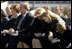 Joining the family of Space Shuttle Columbia Commander Rick Husband, President George W. Bush and Laura Bush bow their heads in prayer during a memorial service at NASA's Lyndon B. Johnson Space Center Tuesday, Feb. 4, 2003. Sitting with the President are Mr. Husband's wife, Evelyn, and children Laura and Matthew. White House photo by Paul Morse.