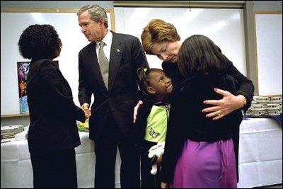 Sandy Anderson, wife of Lt. Col. Michael Anderson, one of the crew members lost aboard the Space Shuttle Columbia, talks with President George W. Bush at the NASA's Lyndon B. Johnson Space Center in Houston, Texas, Tuesday, Feb. 4, 2003. Laura Bush hugs Mrs. Anderson's daughters, Kaycee, 9, left, and Sydney, 11, after the memorial service. White House photo by Eric Draper.