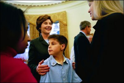 Laura Bush talks with several children of the lost crew members of the Space Shuttle Columbia during their families' visit to the Oval Office Friday, March 7, 2003. From left, they are, Sydney Anderson, 11, David Ramon, 9, and Laura Husband, 12. Their fathers are Lt. Col. Michael Anderson, Col. Ilan Ramon and Col. Rick Husband. White House photo by Eric Draper.