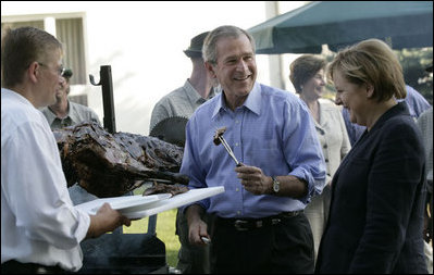 President George W. Bush enjoys a bit of barbeque Thursday, July 13, 2006, as he joins Chancellor Angela Merkel for a barbeque in Trinwillershagen. The President and Mrs. Laura Bush are scheduled to depart Germany Friday for St. Petersburg, Russia.
